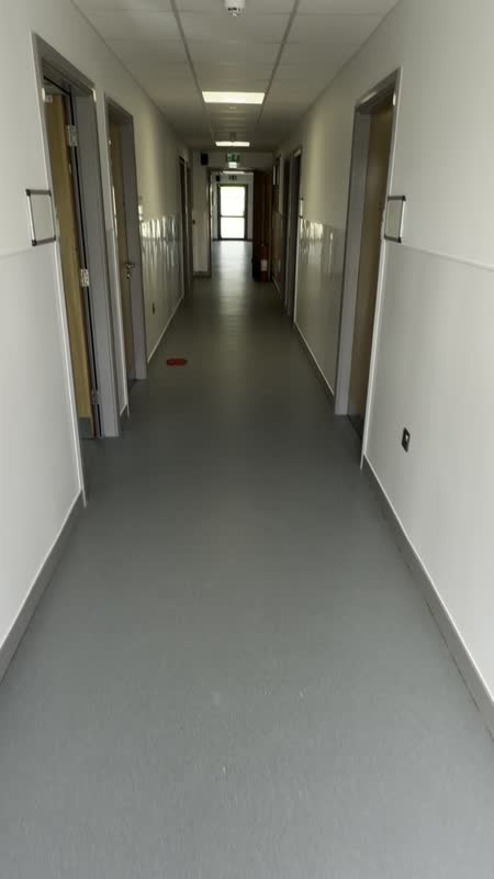 A closer look along a vinyl-floored corridor.