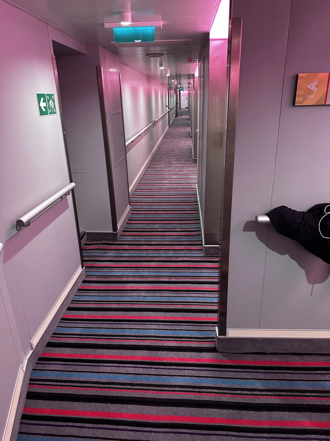 Striped carpet continuing down a long corridor with handrails