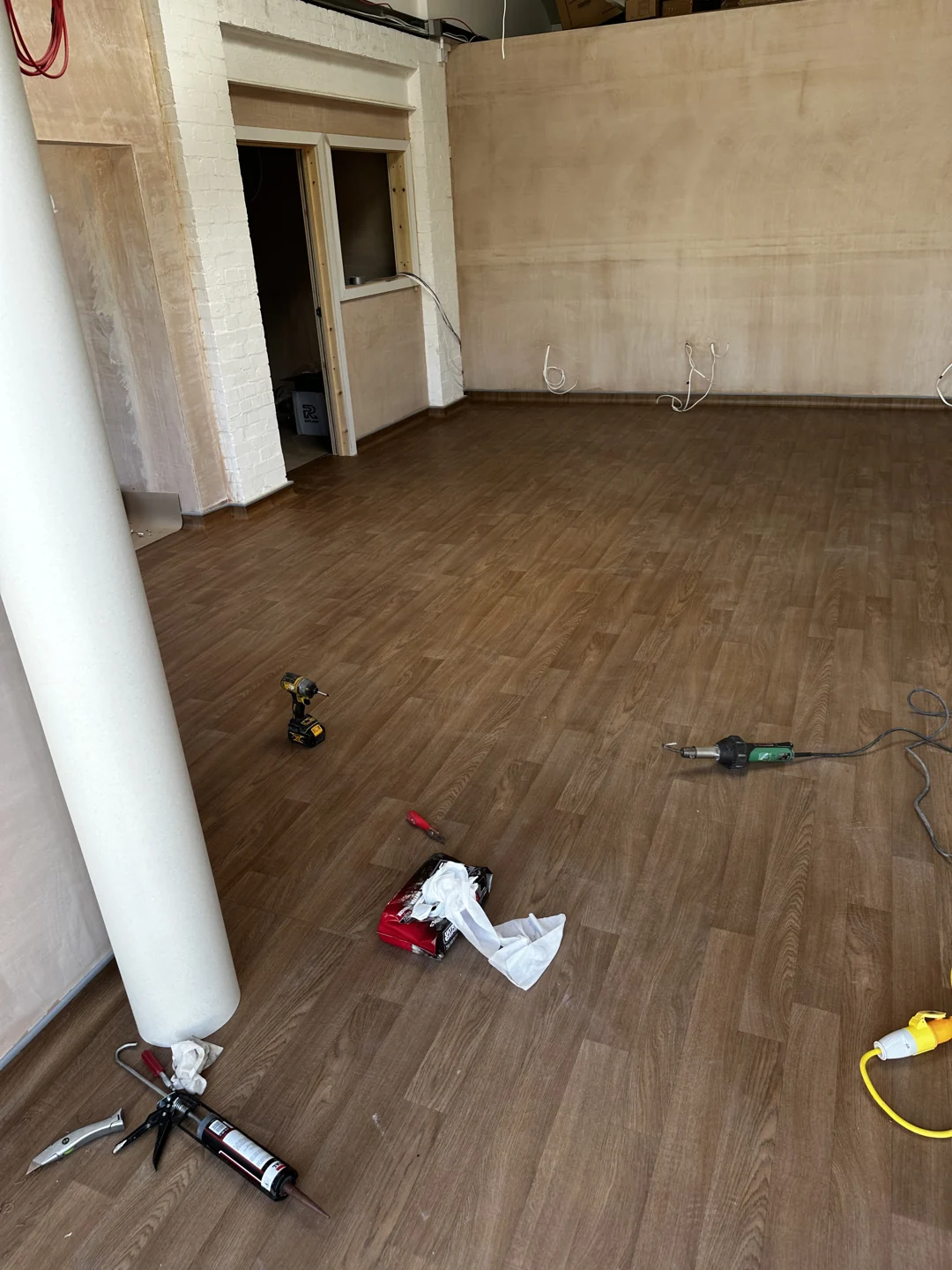 Wood-effect floor in an unfinished room with installation tools on the surface
